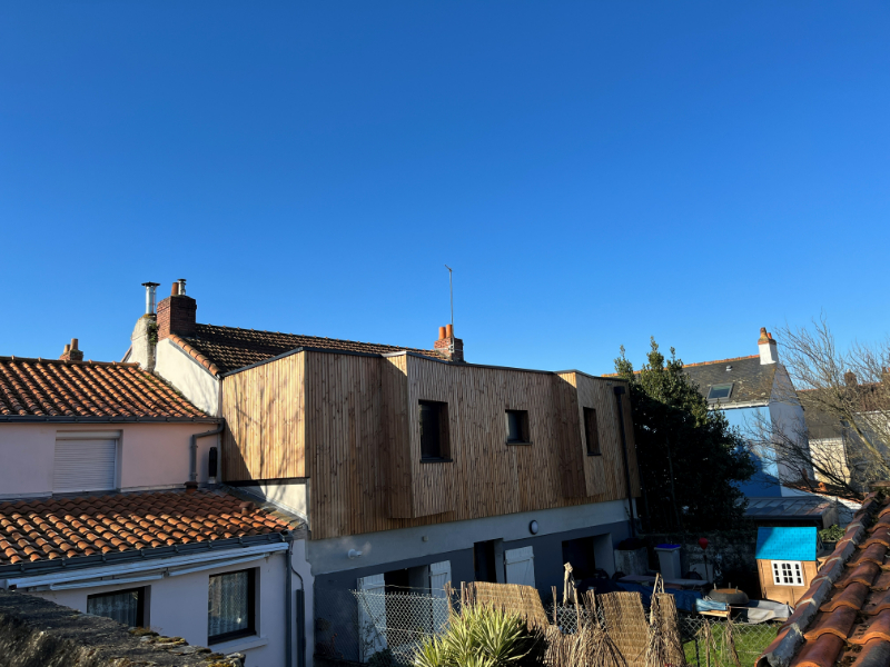 Ajout d'un étage bois avec bardage bois sur une maison dans le centre-ville de Basse-Indre en Loire-Atlantique.